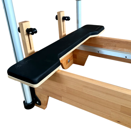 Wooden exercise bench with black seat pad on a white background